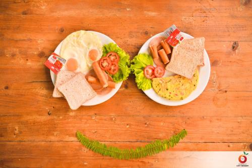 a table with a plate of food with eggs and bread at The Orange City Resort in Ao Nang Beach