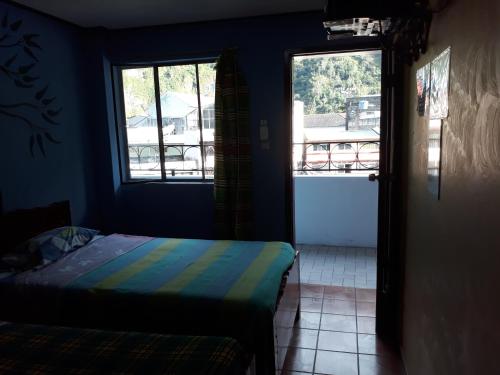 a bedroom with a bed and a door to a balcony at Transilvania in Baños