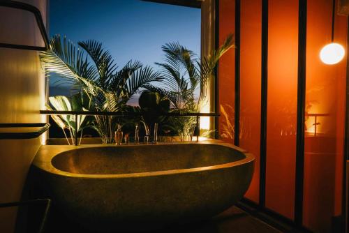 baño con bañera con plantas en una ventana en Urban Residences - Siem Reap, en Siem Reap