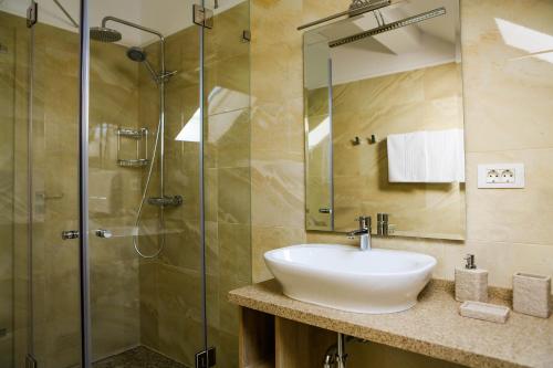 a bathroom with a sink and a glass shower at Reve Mariage in Bucharest