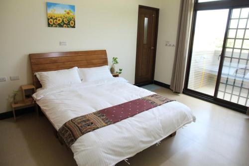 a large bed in a bedroom with a large window at Ancient Official Road Homestay in Jinhu