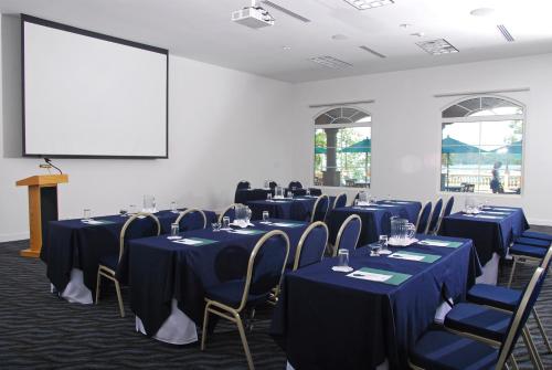 a conference room with blue tables and chairs and a screen at Radisson Hotel Panama Canal in Panama City