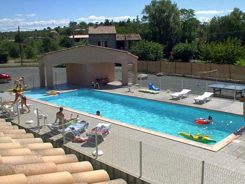 a large swimming pool with chairs and people in it at les cigales in Lablachère