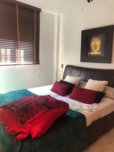 a bedroom with a large bed with red pillows at Lo Chalet in Les Cases d'Alcanar