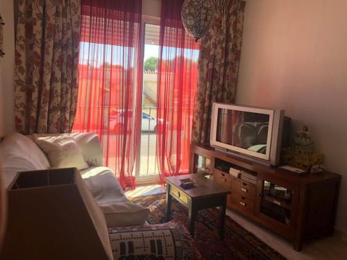 a living room with a tv and a window at Lo Chalet in Les Cases d'Alcanar