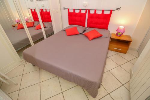 a large bed with red pillows in a bedroom at Casa Bellavista in Terzorio