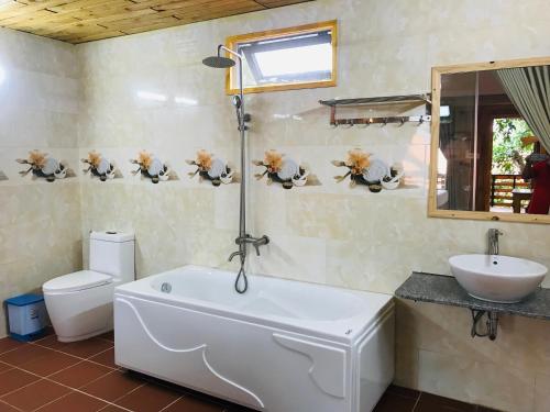 ein Badezimmer mit einer Badewanne, einem WC und einem Waschbecken in der Unterkunft Ong Lang Garden Resort in Phu Quoc
