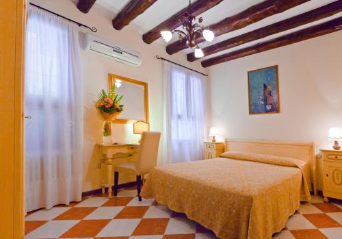 a bedroom with a bed and a desk and a table at Hotel Henry in Venice