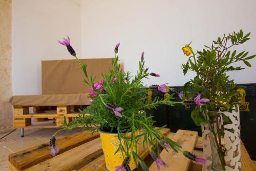 two vases with flowers on a table in a room at Masseria Poli Country House in Conversano