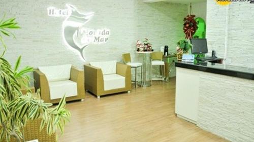 a lobby with chairs and a counter in a room at Hotel Morada do Mar in Guarujá