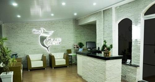 a lobby with a waiting room with a desk and chairs at Hotel Morada do Mar in Guarujá