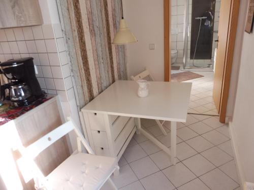 einen kleinen weißen Tisch und Stuhl in einer Küche in der Unterkunft Ferienwohnung Simone in Radebeul