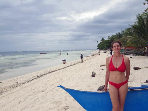 a woman in a red bikini standing on a beach at MJ Room Rental in Panglao
