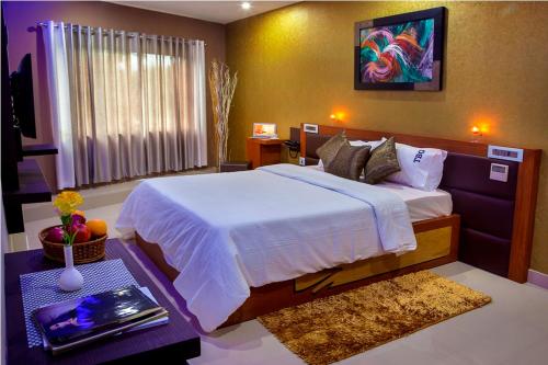 a bedroom with a large bed and a table at ALSHIFA TBG RESIDENCY in Perintalmanna