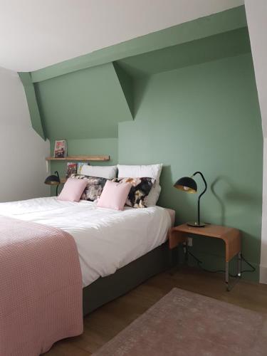 una camera da letto con letto e cuscini rosa di Duplex 50 m2 au pied des planches a Trouville-sur-Mer