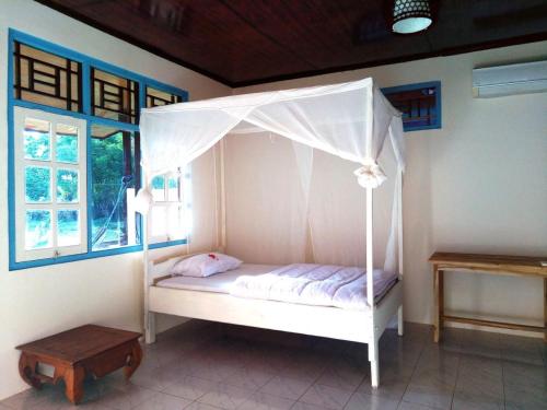 a bed with a canopy in a room at Lakey Beach Inn hotel in Huu