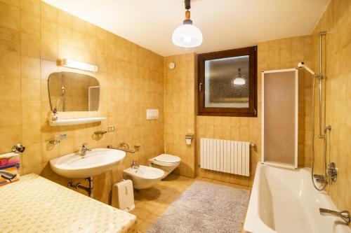 a bathroom with a sink and a toilet and a tub at Casa Matie in Selva di Val Gardena
