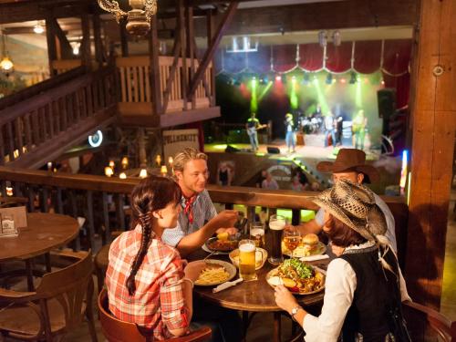 a group of people sitting at a table eating food at Pullman City Westernstadt in Eging