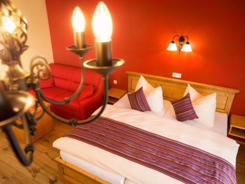 a hotel room with a bed and a red chair at Pullman City Westernstadt in Eging