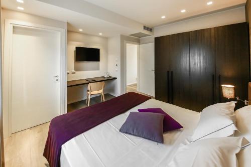 - une chambre avec un grand lit blanc et un bureau dans l'établissement La Bella Modena, à Modène