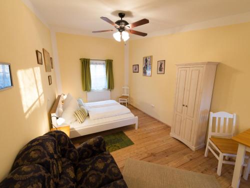 a living room with a bed and a ceiling fan at Pullman City Westernstadt in Eging