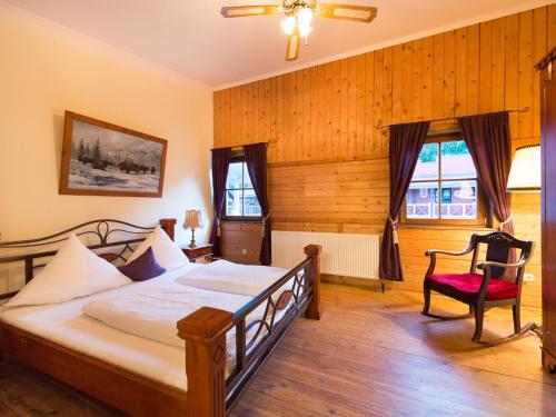 a bedroom with a bed and a red chair at Pullman City Westernstadt in Eging am See