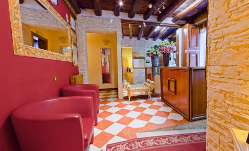a bar with red chairs and a red wall at Hotel Henry in Venice