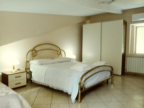 a bedroom with a white bed and a nightstand and a bed sidx sidx sidx at B&B Mansarda in Caserta