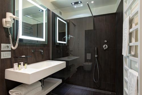 bagno con lavandino bianco e specchio di Hotel Tiferno a Città di Castello