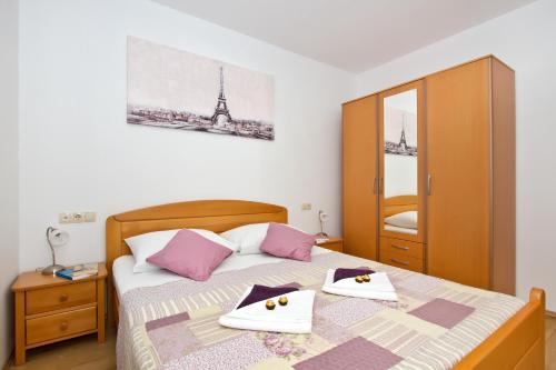 a bedroom with a bed with two towels and the eiffel tower at Family apartment in Omiš