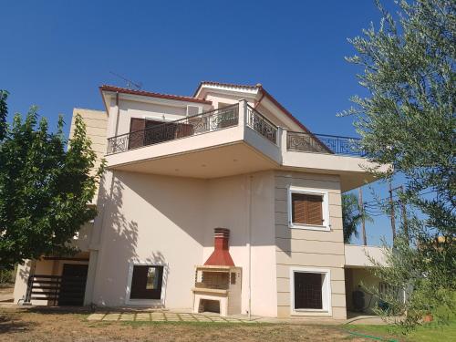 a large white building with a balcony on it at Dimitris Villa in Aígio
