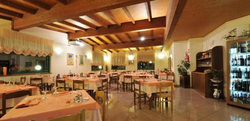 jadalnia ze stołami i krzesłami w restauracji w obiekcie Hotel Torre w mieście Sondalo