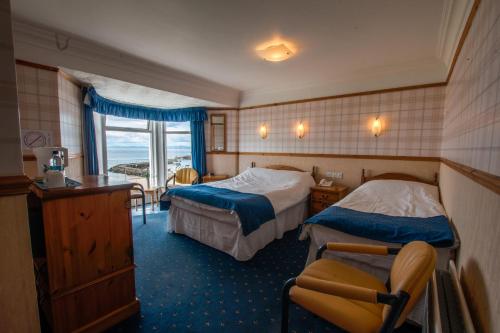 a hotel room with two beds and a window at Harbour Heights B&B in Portrush