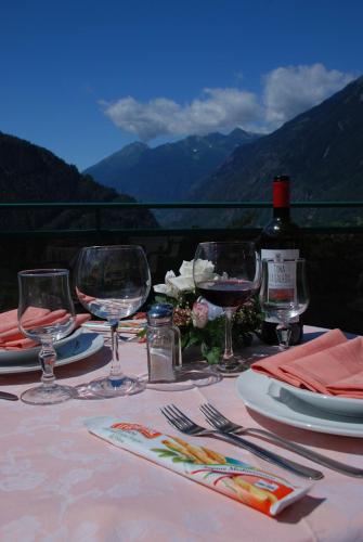 a table with wine glasses and a bottle of wine at Hotel Torre in Sondalo