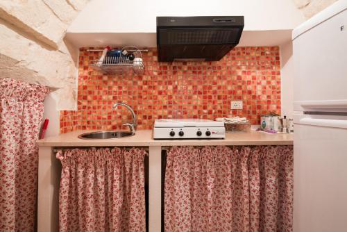 a small kitchen with a sink and a stove at White House Flats & Studios in Ostuni