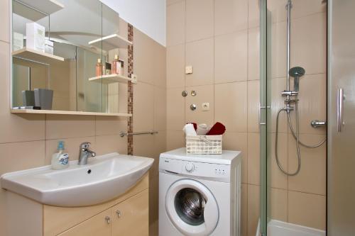 a bathroom with a washing machine and a sink at Family apartment in Omiš