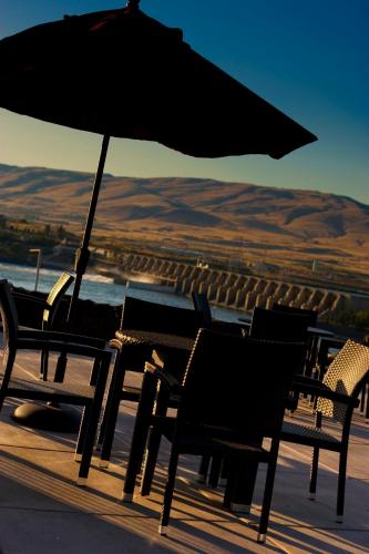 a group of chairs and an umbrella on a deck at Celilo Inn in The Dalles