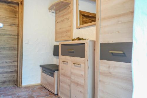 a kitchen with wooden cabinets and a refrigerator at Almchalet Pöllatal in Rennweg