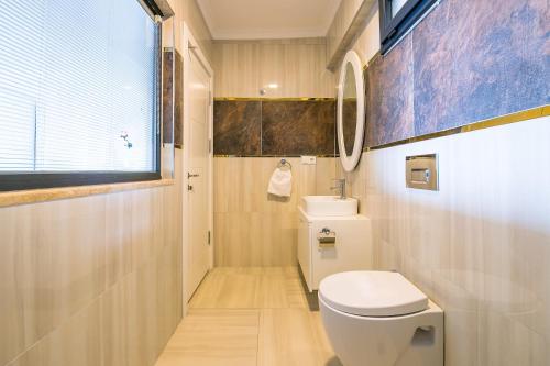 a bathroom with a white toilet and a window at Villa Spring- Hill Villas Kalkan in Kaş