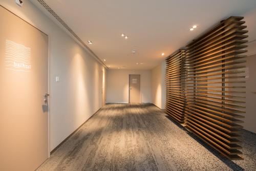 an empty hallway with a wooden wall and a door at HOTEL illuster - Urban & Local in Uster