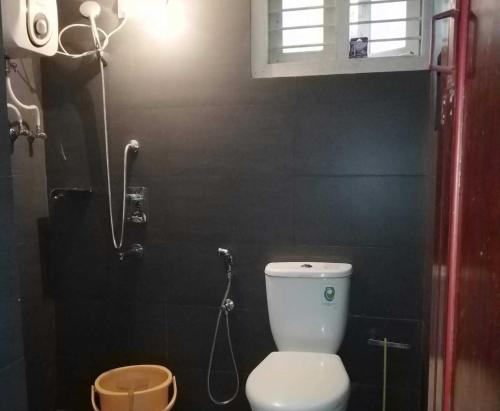 y baño pequeño con aseo y ducha. en Tagore Homestay Villa Trivandrum, en Trivandrum