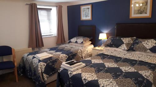 ein Hotelzimmer mit 2 Betten und einem Fenster in der Unterkunft Blueberry Two Bedroom Suite in Douglas