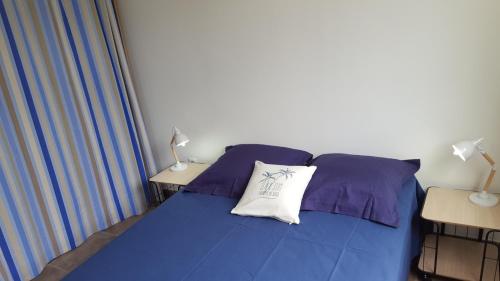 a bedroom with a blue bed with a pillow on it at LA YOLE des Caraïbes in Les Anses-dʼArlets