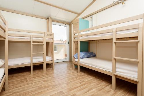 a room with four bunk beds and a window at Camping la Sierrecilla in Humilladero