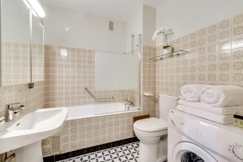 Un baño blanco con lavabo e inodoro. en Stylish Loft in Saint-Germain Des Près, en París