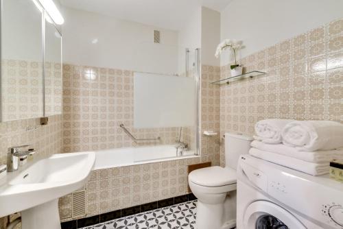 a white bathroom with a sink and a toilet at Luxury Loft in Saint-Germain Des Près in Paris