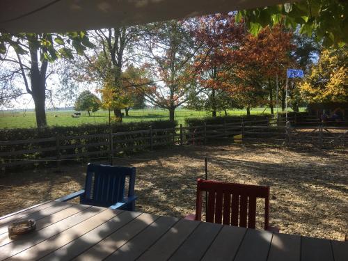 a wooden table with two chairs and a fence at B&B Le Moulin de Fernelmont in Forville