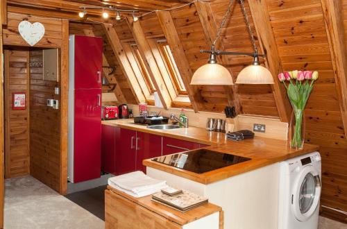 a kitchen with red cabinets and a red refrigerator at Grafham Water Lodge in Grafham