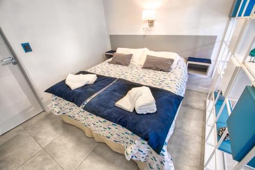 a bedroom with a bed with blue sheets and pillows at Studio Belgrano in San Carlos de Bariloche