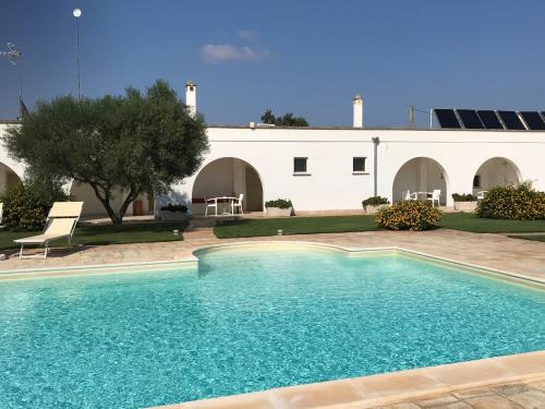 a swimming pool in front of a white building at Relais Masseria della Colomba - Agriturismo in Francavilla Fontana